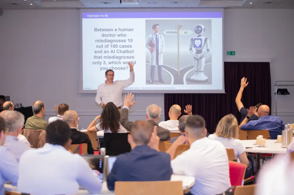 Giovanni Giamminola on stage during an executive workshop, audience raising hands